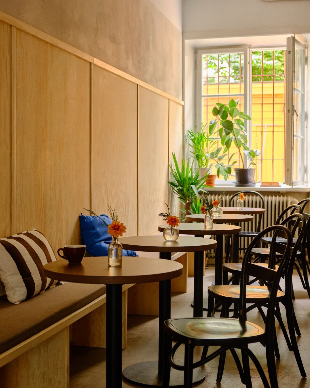 Round tables and wooden wall panelling in the seating area of Tigre Kaffebar